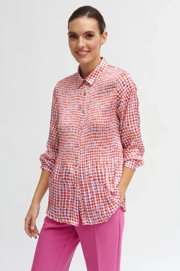 This Pleated Flowing Dana Blouse is a beautifully designed piece that combines elegance with a bit of artistic flair, making it a statement outfit piece.