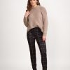 The Vassalli Skinny Leg Printed Pull-On Ponti Pant is a mid-weight stretchy pant featuring a black, red, and beige plaid design.