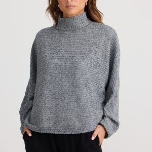 Experience comfort and style with a roll-style collar, batwing sleeves, and a relaxed fit. Made from a chunky ripped knit fabrication for a cozy look.