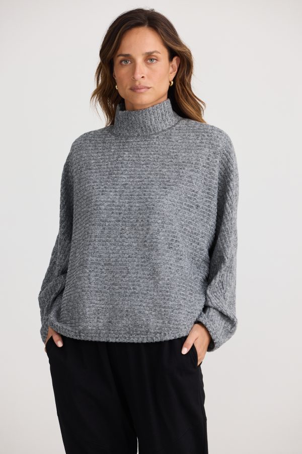 Experience comfort and style with a roll-style collar, batwing sleeves, and a relaxed fit. Made from a chunky ripped knit fabrication for a cozy look.